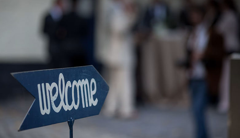 A sign with an arrow and text that says &lsquo;Welcome.&rsquo;