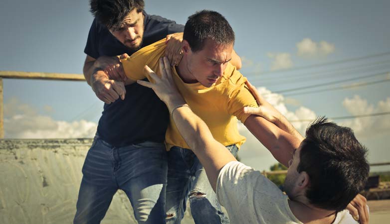 Three young men in a fight.