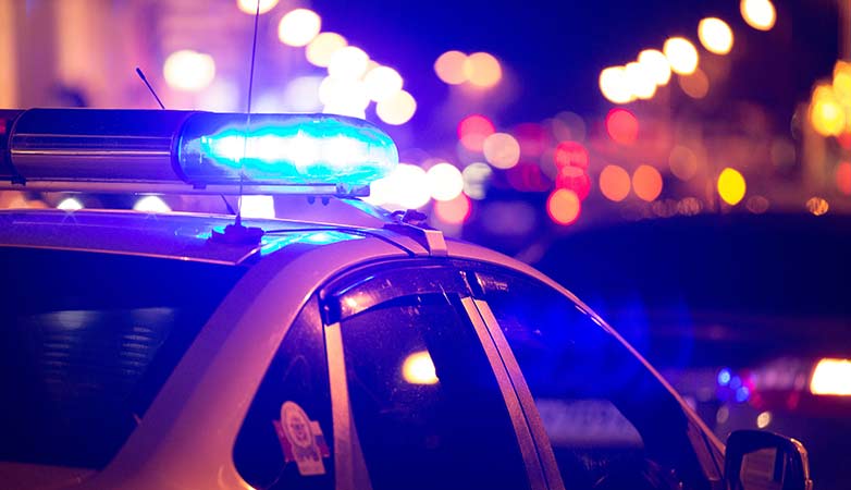 Police car at night with its sirens on.